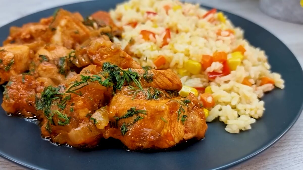 Куриное филе на сковороде с ароматным гарниром из риса и овощей.