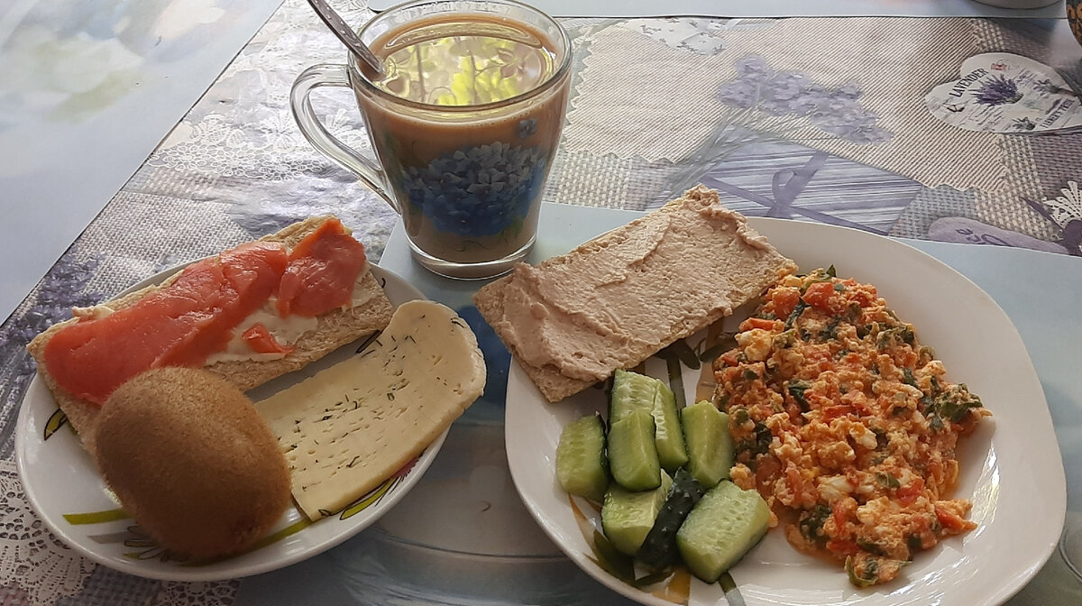 Стандартная яичница с помидором и шпинатом. На одном хлебце паштет из печени трески, на втором - сливочное масло с рыбкой. Кофе с кусочком сыра. Киви.