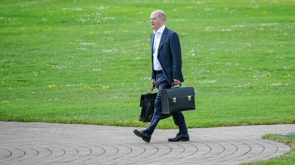    Канцлер Германии Олаф Шольц готовится к посадке на вертолет © AP Photo / Kay Nietfeld