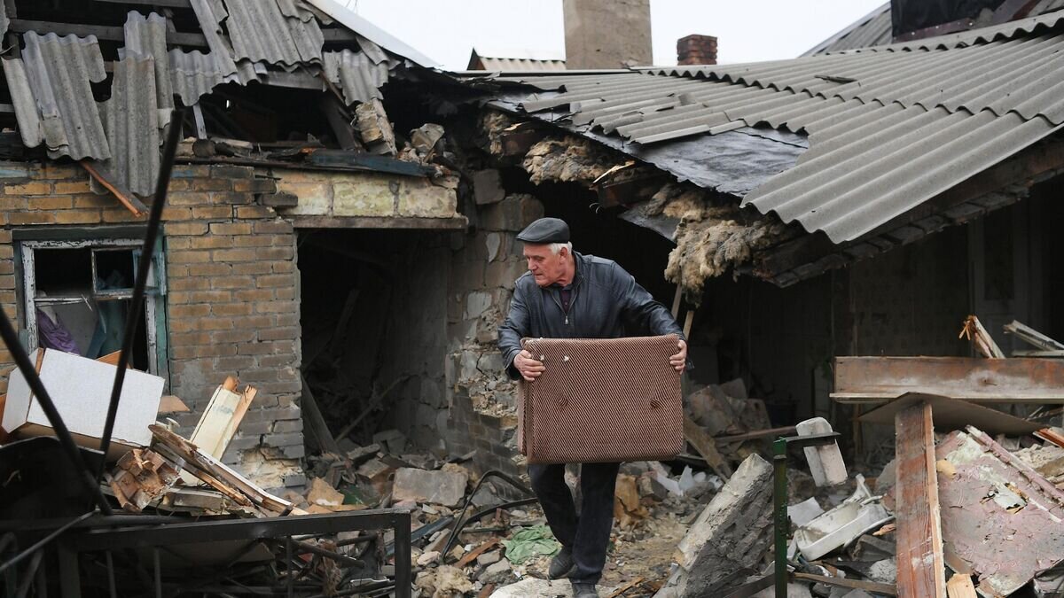    Местный житель во дворе разрушенного жилого дома в результате обстрела в одном из пригородных районов Донецка© РИА Новости / Алексей Майшев