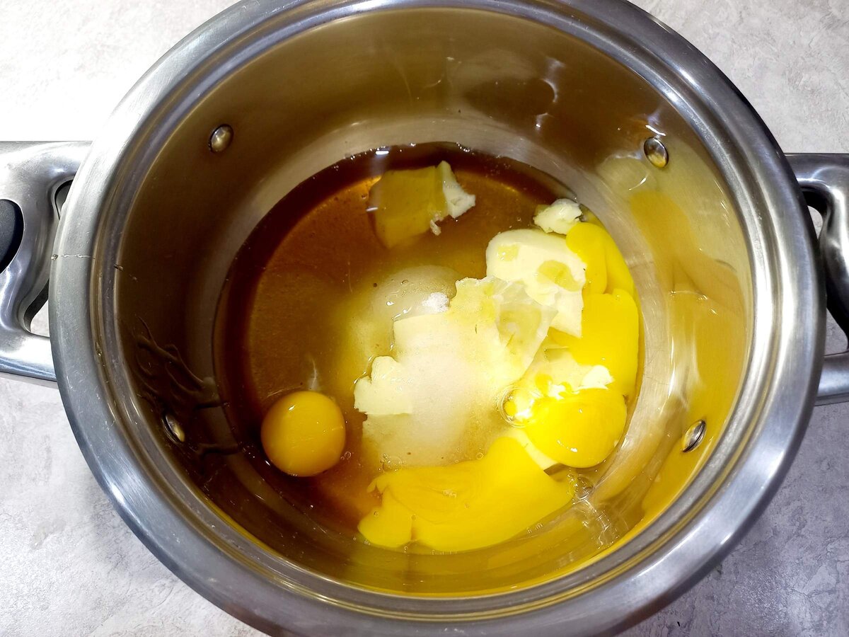 В кастрюлю положить следующие ингредиенты: масло комнатной температуры,  сахар, мед,  яйца.