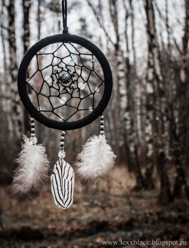 Амулет украшен перьми и бусинами.