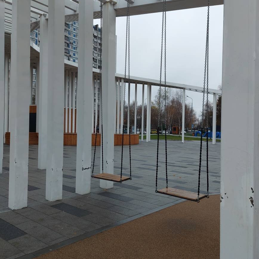 Качельки и сцена на заднем фоне. На качельках я немного покачалась