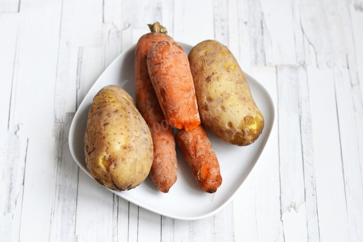Морковь и картофель вымойте со щеткой, не очищая от кожуры. Выложите овощи в кипящую воду и отварите до готовности. Затем охладите и очистите.