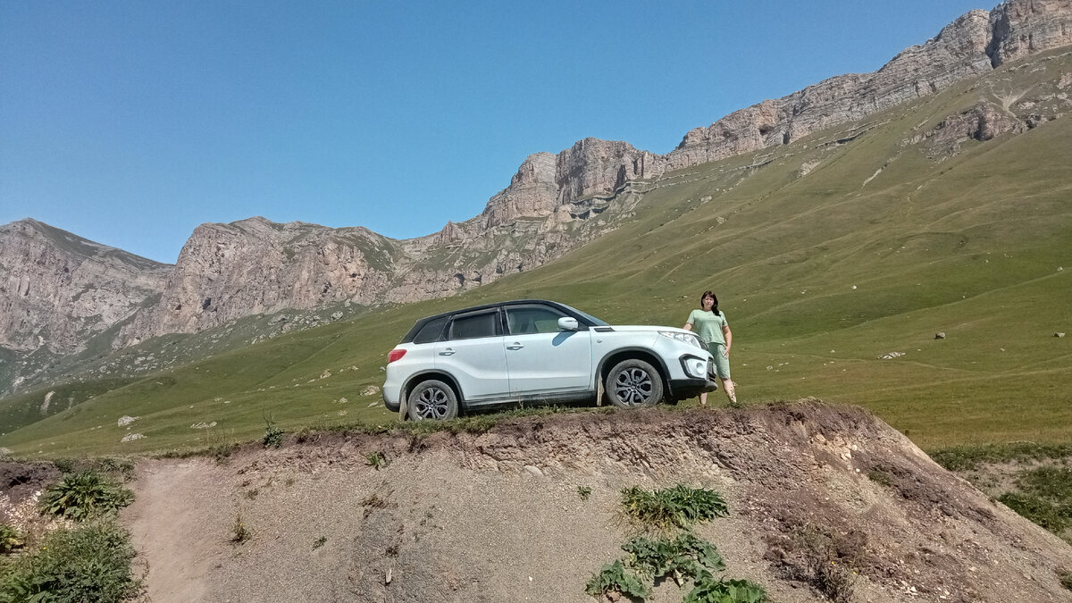 На фоне скал.