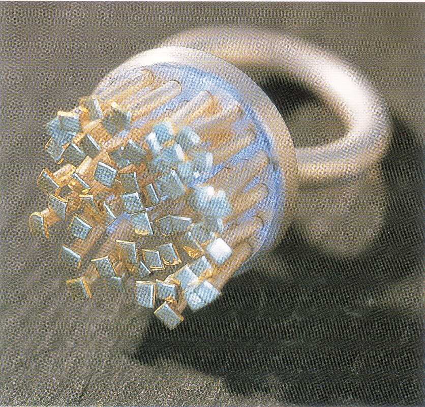 Белое сияние, достигнутое травлением серебра, контрастирует с золотом, которое применено для подчеркивания плотного кластера стеблей в этом кольце.