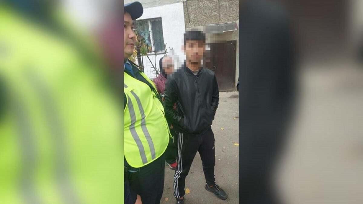    Полицейский стоит с задержанным:polisia.kz