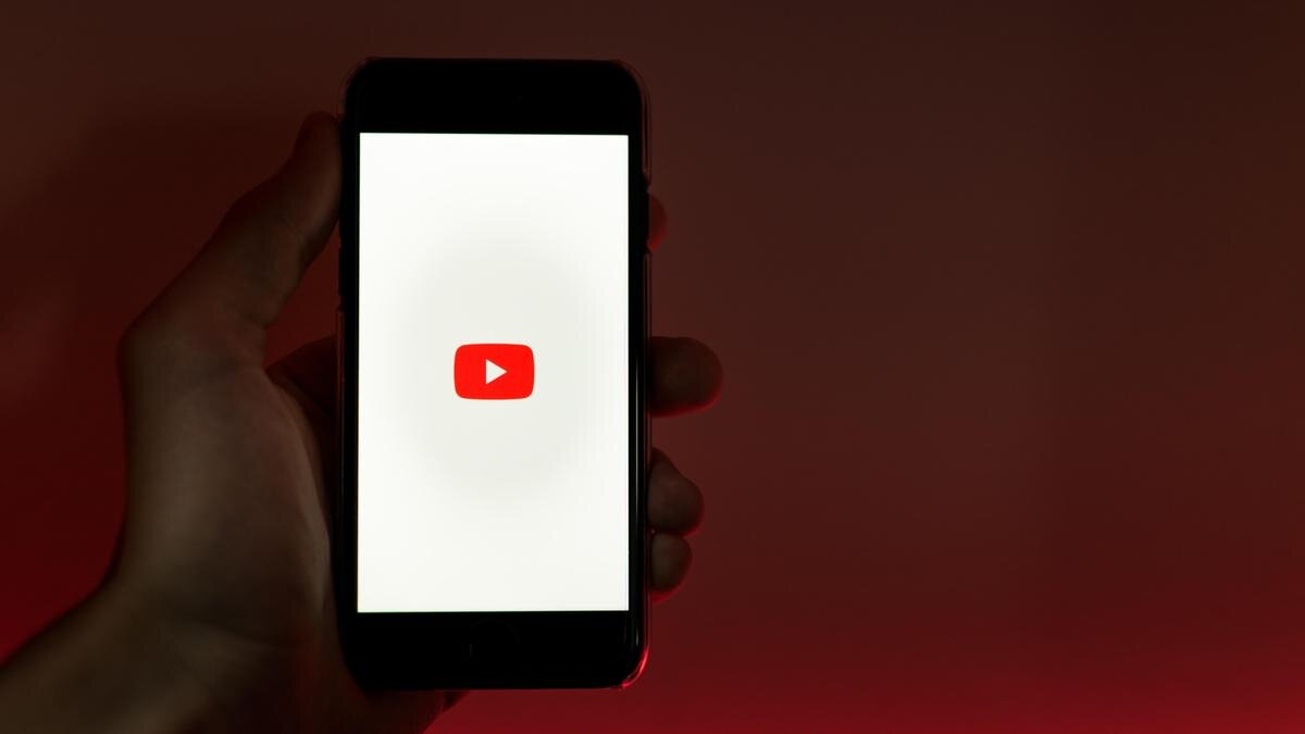    Человек держит в руках смартфон с включённым Youtube:pixabay.com