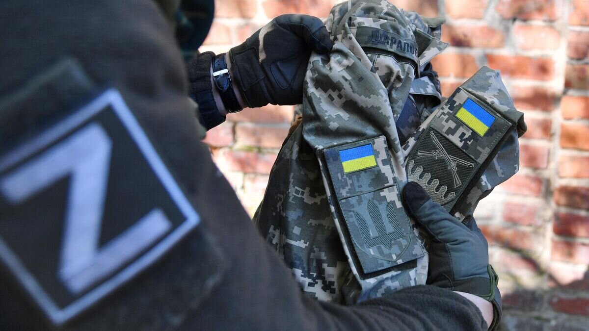    Боец МВД ЛНР демонстрирует форму, найденную в доме участника боевых действий АТО в селе Рубежное © РИА Новости / Виктор Антонюк