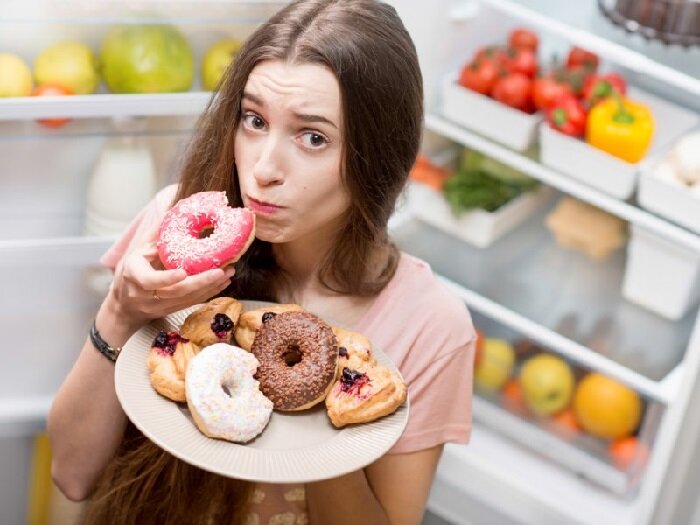 Фото Девушка ест много сладкого.