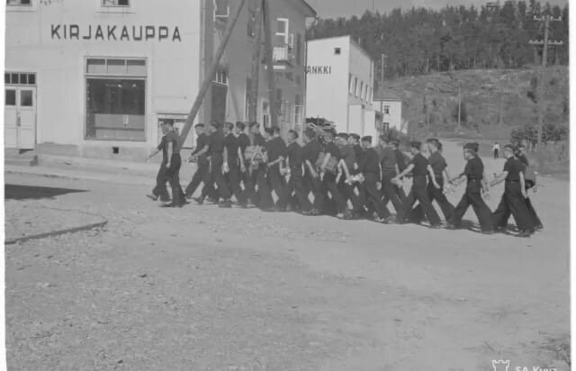 Финские моряки идут по г. Лахденпохья. На заднем плане второе по счёту здание, где сейчас находится магазин «Гарант». Фото: SA-KUVA. Финский военный фотоархив.