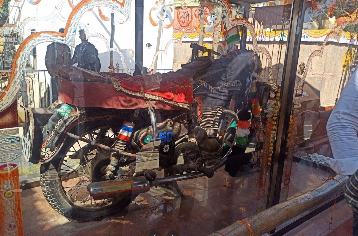 Украшенный мотоцикл Банны в храме Ома Банны. Рядом ящик для пожертвований.