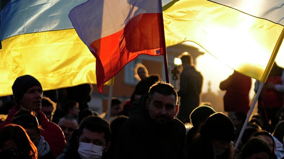    Люди с флагами Польши и Украины в Варшаве© AP Photo / Petr David Josek