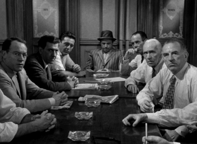 Кадр из (12 Angry Men, 1956). Молодого парня обвиняют в убийстве, ему грозит смертная казнь. 12 присяжных должны вынести вердикт, и только один из них усомнился в доказательствах и этим спас жизнь невиновному. Источник: kinopoisk.ru 
