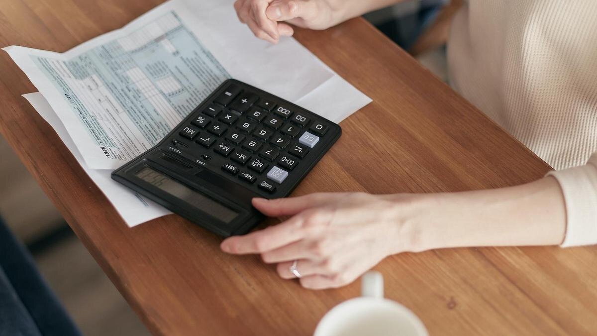    Девушка выполняет расчеты на калькуляторе:pexels.com