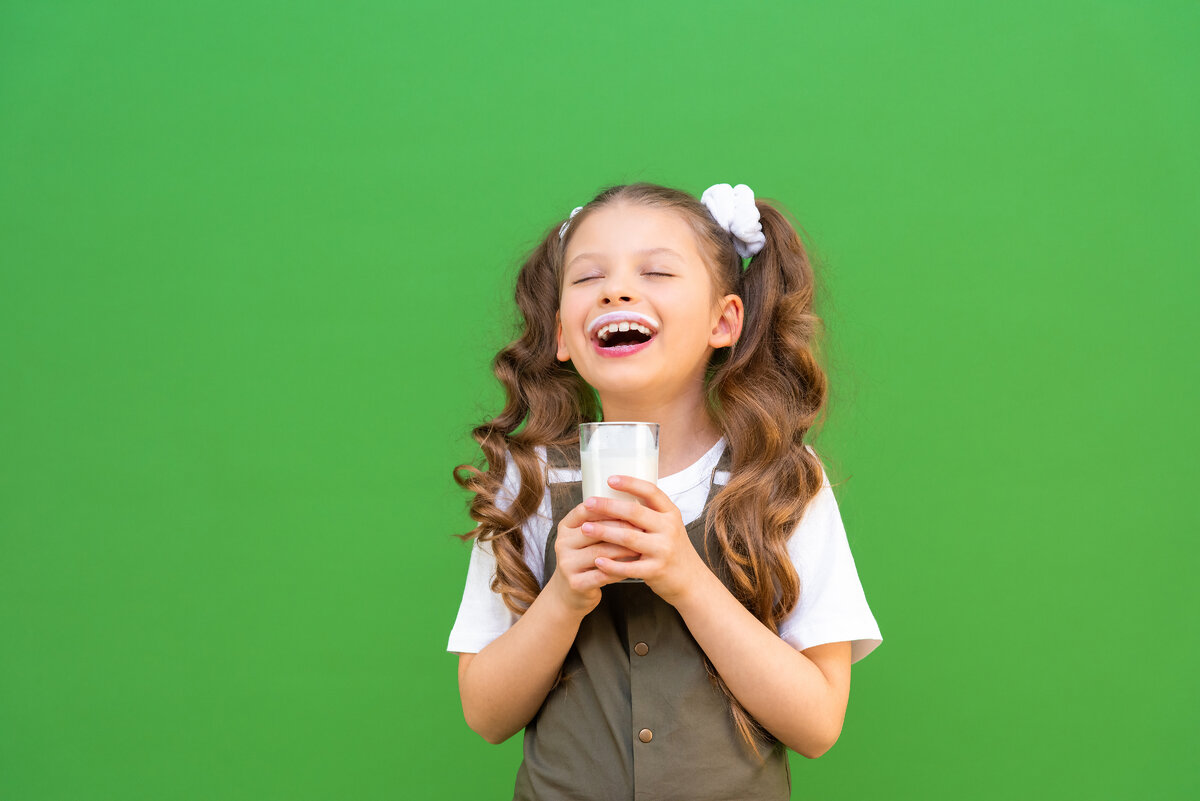 Ребенок пьет ряженку.