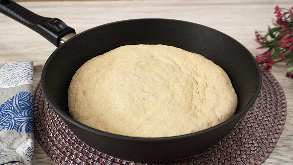 Блюдо в сковороде покрытое пленкой из хлеба сверху.