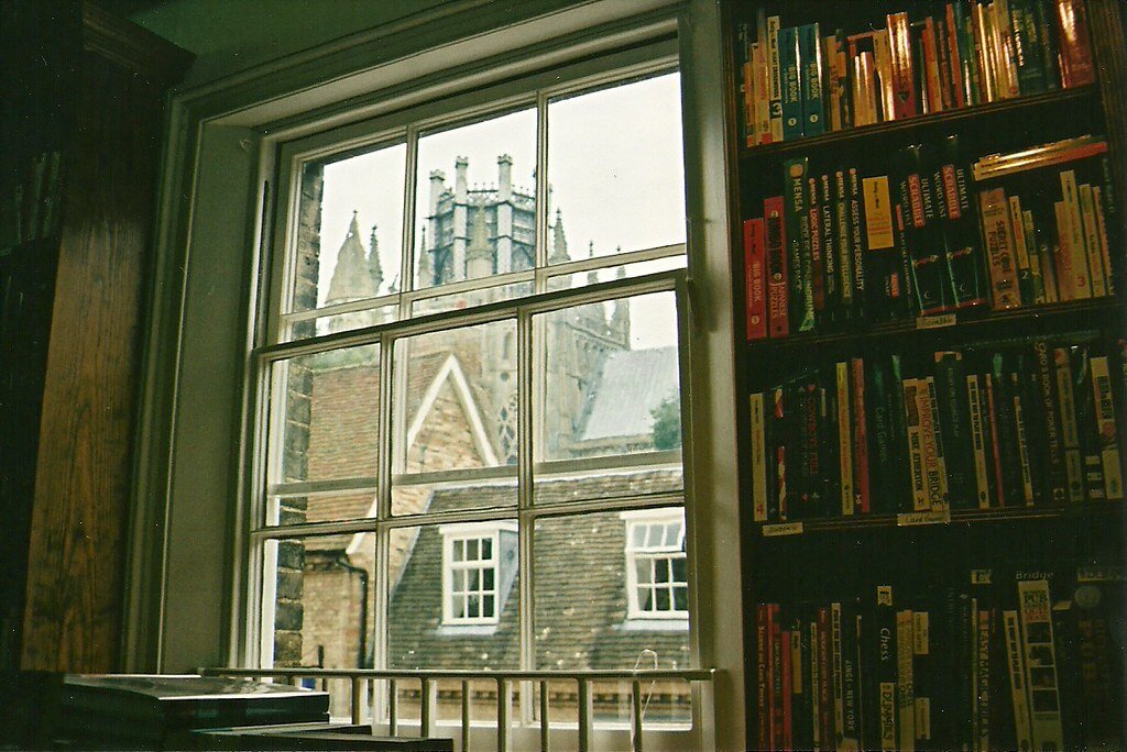 The window is open. Окно в библиотеке. Окно в библиотеке старинное. Вид из окна библиотеки. Книга на окне.