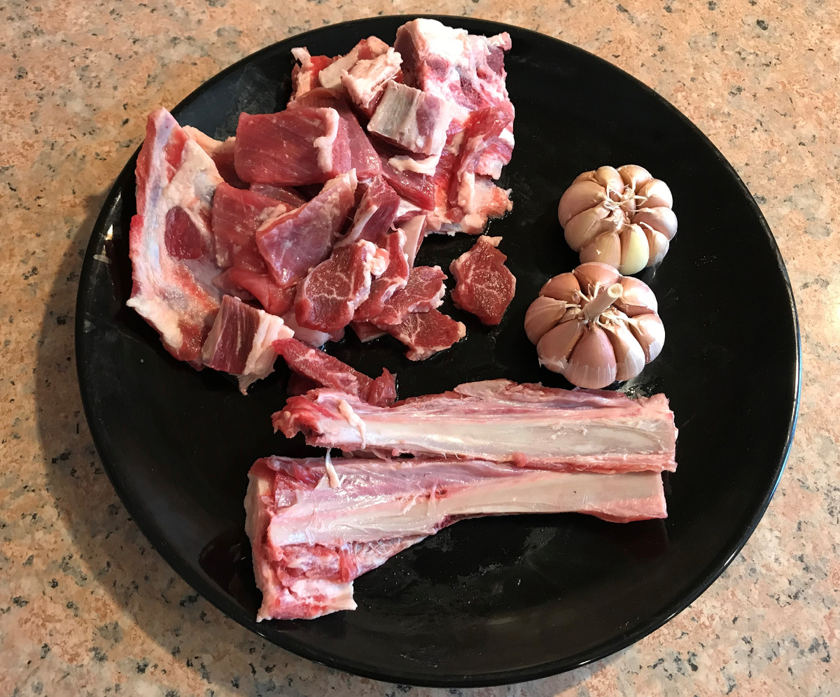 Баранину для плова как следует промыть и нарезать мелкими кубиками. Отчистить головки чеснока от основной шелухи и сделать продольный разрез по зубчикам.              (Я добавил ещё пару рёбрышек, для вкуса и жирности плова)