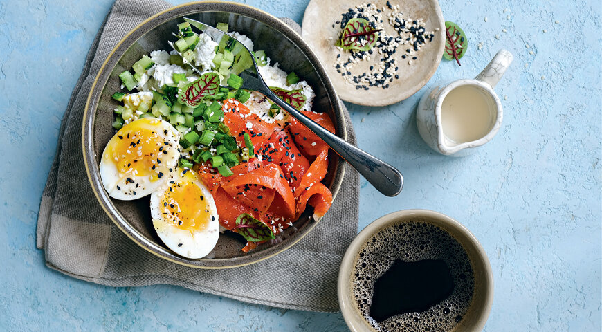 Творожный боул на завтрак, где в качестве топпинга – копченый лосось, сваренное всмятку яйцо, нарезанный кубиками свежий огурец и много зелени.