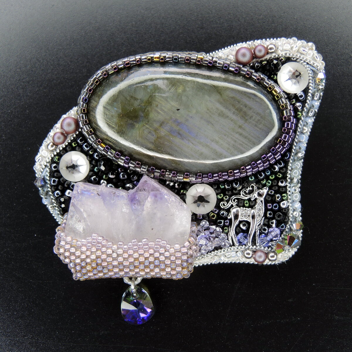 Спектролит в работе может казаться просто серым камнем, но всё это обман: он умеет расцветать подобно полярному сиянию. А еще в работе настоящая друза аметиста, согласившаяся стать ледяной глыбой.