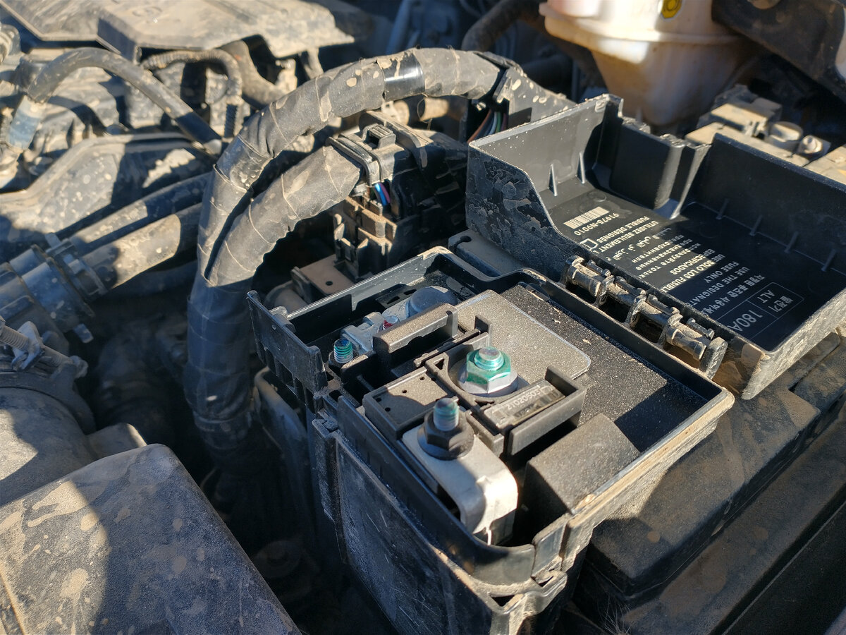 Это - аккумулятор машины, открытый. Я не сторонник чистки подкапотного пространства и, к тому же, я часто езжу по грязи и лужам, в общем под капотом у моей машины грязно.