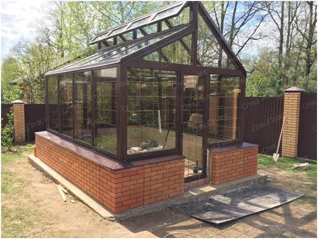 Теплица по Митлайдеру от СпецПласт  из стеклопакетов на стальном каркасе с облицовкой кирпичом фундамента 