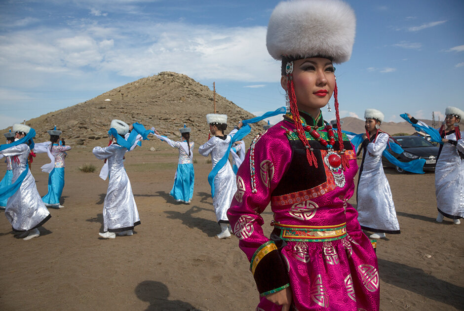 Девушка в национальном костюме принимает участие в конкурсе красоты на пятом международном этнокультурном фестивале «Ёрдынские игры» в Ольхонском районе Иркутской области на фоне священной горы Ёрд 
Фото: Николай Винокуров / Фотобанк Лори
