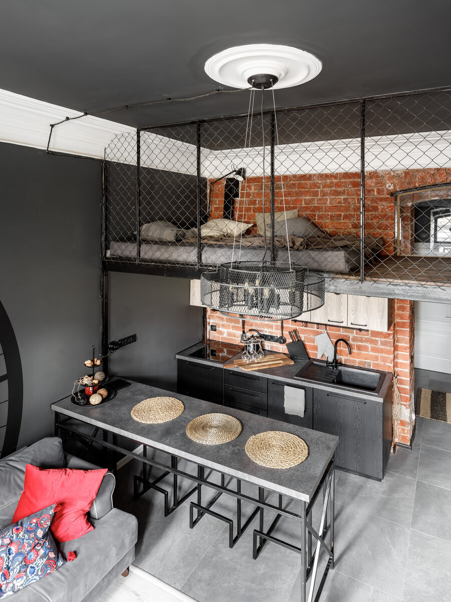 На стенах в кухне-гостиной и других комнатах присутствует кирпичная кладка, её обнаружили под слоем старой отделки и реставрировали, обновив затирку на швах. Высокий карниз — также часть исторической отделки.