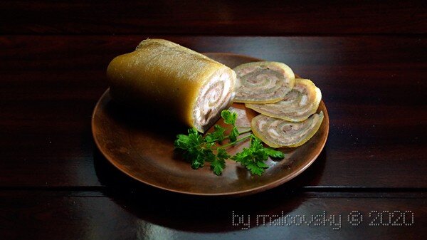 Рулет из свиной шкуры с мясом и чесночным соусом.