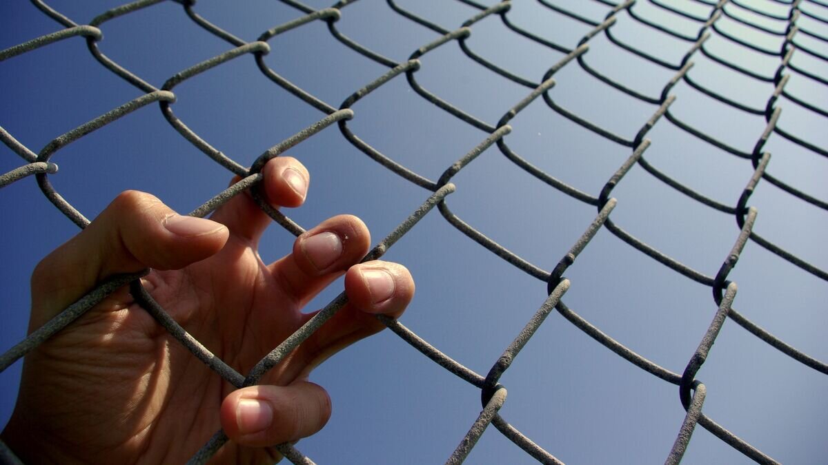    Человек за решеткой© Fotolia / Matthew Lettrich