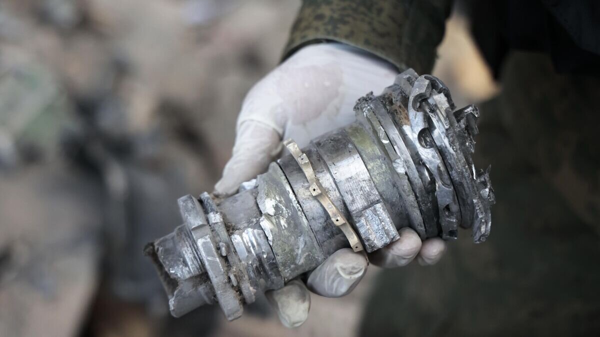    Следователь СЦ РФ демонстрирует часть снаряда на месте пострадавшего в результате обстрела со стороны ВСУ здания городской администрации в центре Донецка© РИА Новости / Сергей Аверин