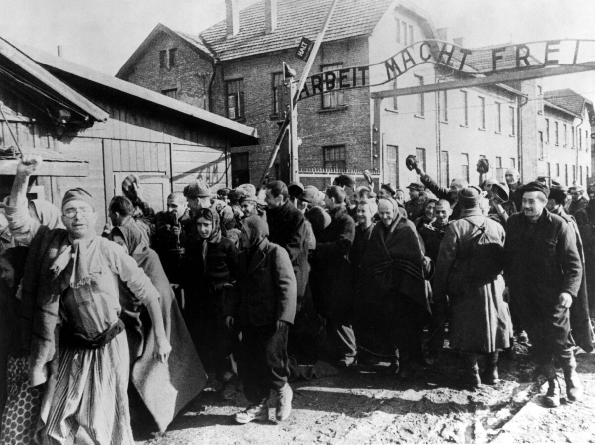 Освобожденные узники выходят из главных ворот концлагеря Аушвиц I после освобождения лагеря частями Красной армии, февраль 1945 года