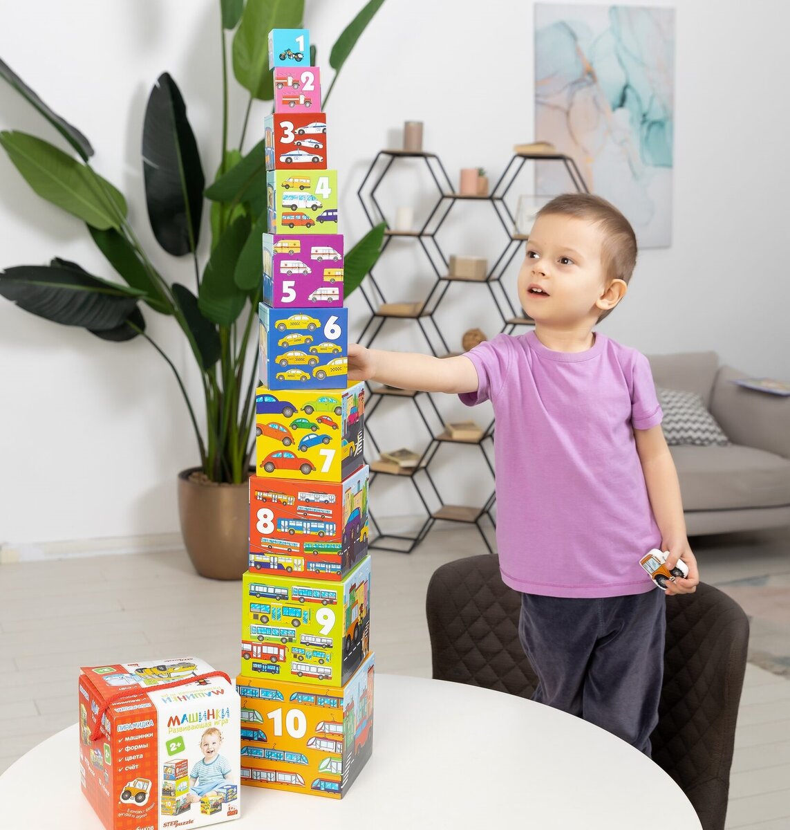 Мальчик играет в развивающую игру «Машинки. Пирамидка. 10 кубиков»