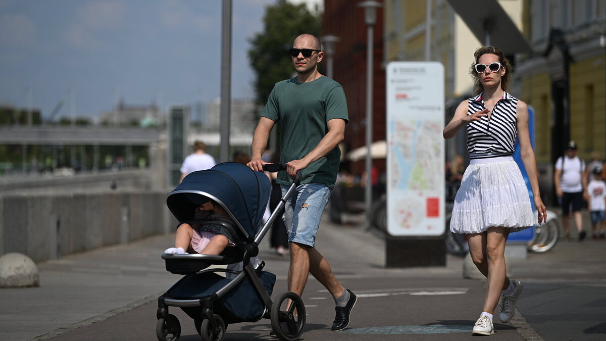    Жители Москвы гуляют с ребенком в коляске по набережной© РИА Новости . Павел Бедняков