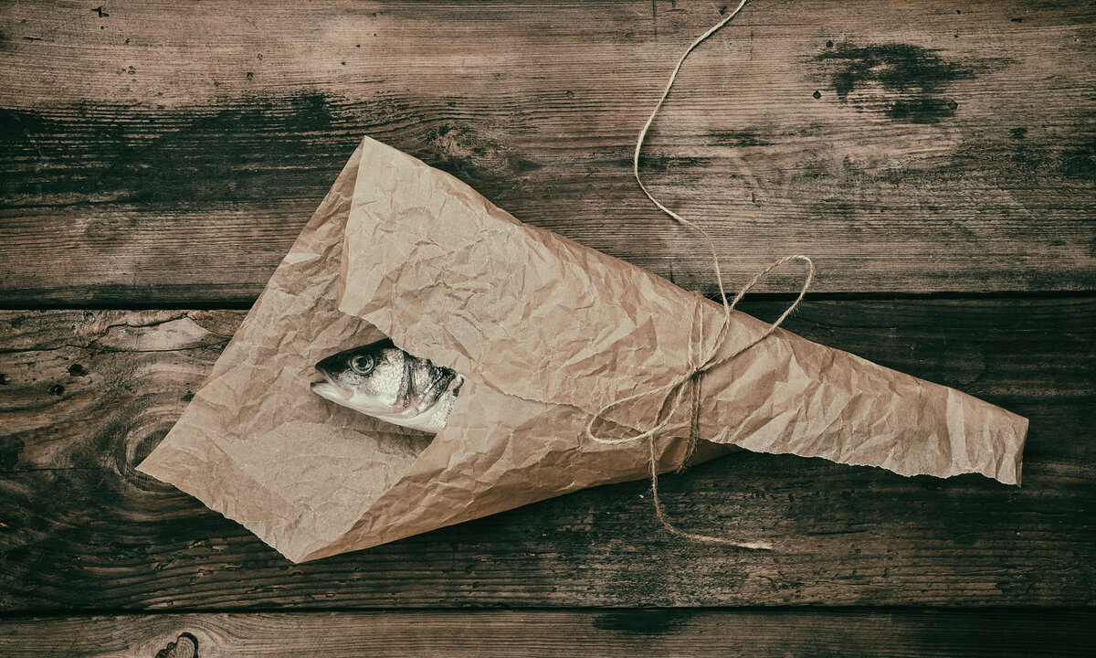 Тут рыбу заворачивали. Упакованная рыба в бумаге. Рыба завернутая в газету. Рыба в крафтовой бумаге. Завернутая рыба.
