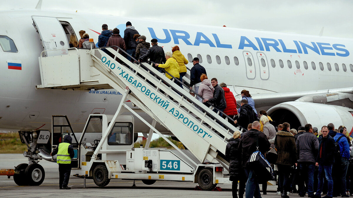    Пассажиры поднимаются по трапу в самолет авиакомпании Ural Airlines в аэропорту "Новый" в Хабаровске.© РИА Новости . Игорь Онучин