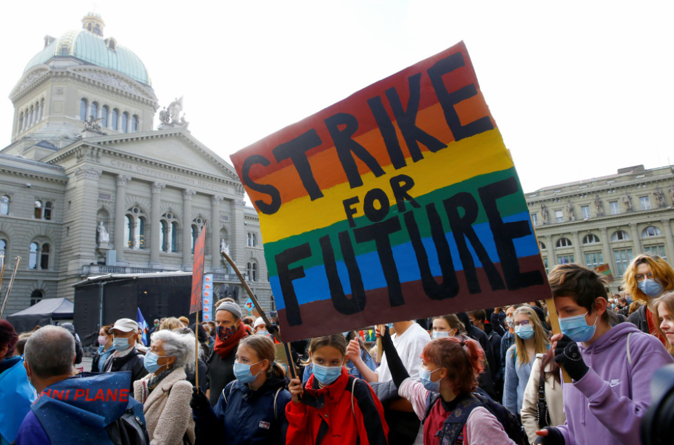 Протестующие принимают участие в Глобальной климатической забастовке движения "Пятницы за будущее" перед зданием Бундесхауса, резиденции федерального парламента Швейцарии на площади Бундесплац в Берне, Швейцария, 22 октября 2021 года. Фото REUTERS/Arnd Wiegmann.