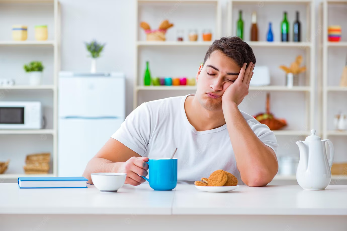 Сонливость после еды причины. Сонный человек завтракает. Сонный завтрак. Человек Сонный за завтраком картинка. Сонный человек с кофе.