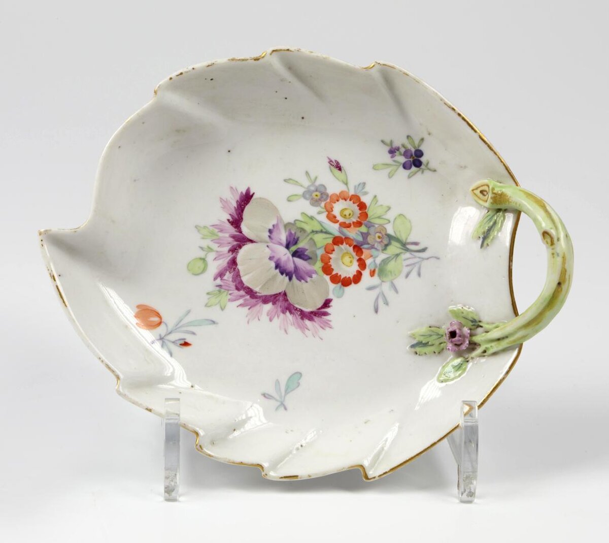 Компотьер в виде листа из Вседневного сервиза. ИФЗ, 1780-1796. Лепка, роспись надглазурная полихромная, позолота. размеры: 4,8*18,0*14,5 см. Собрание Эрмитажа. Предмет поступил в 1950-м году. Передан из Музея Этнографии народов СССР. Инв. номер ЭРФ-11. Изображение взято из каталога Эрмитажа. Хотя в каталоге Эрмитажа утверждается, что предмет изготовлен на ИФЗ, возможно, что его изготовили у Гарднера. Это было бы логично, раз у Гарднера уже была такая форма.