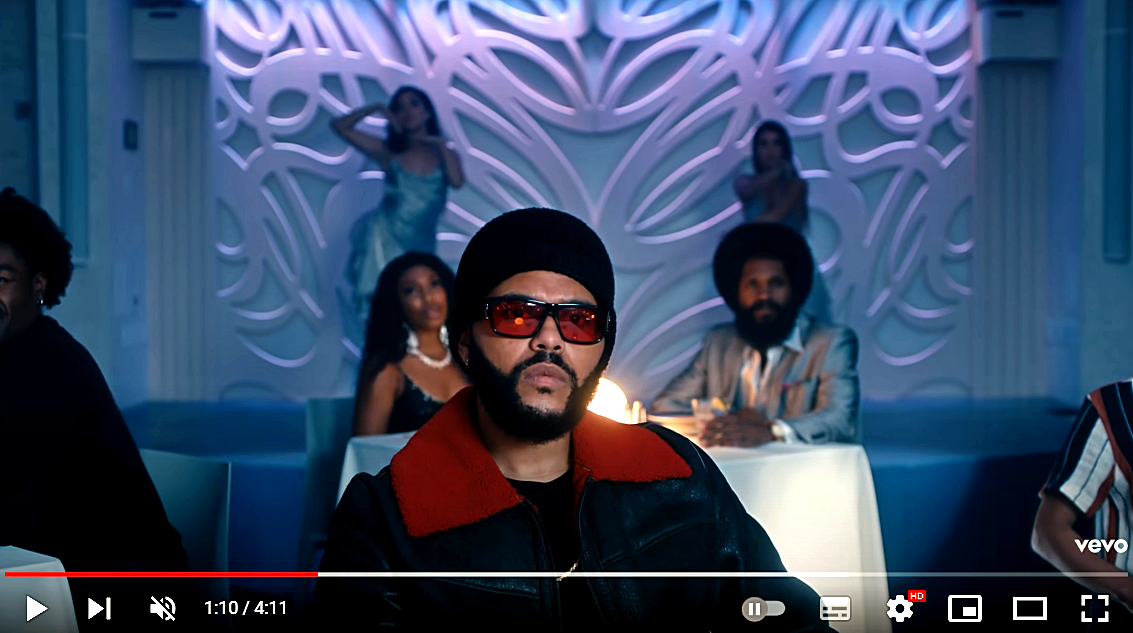 The Weeknd в красной одежде, символизирующей жертвоприношение — развлечение, которое происходит за закрытыми дверями на элитных вечеринках.