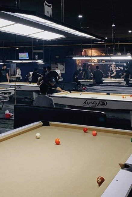 Английское слово «pool», под которым мы подразумеваем бильярд в США на самом деле ничего общего с этой игрой не имеет. В то время ключевыми развлекательными местами были ипподромы со скачками. В пул-румах – местах для ставок скапливалось много народу. Чтобы посетители могли хоть немного отдохнуть и скоротать время там начали ставить столы для бильярда. Спустя время пул-румы стали использоваться для полноценной игры в бильярд. А само слово “пул”, которое переводится как ставка стало означать название американского бильярда.

Американский пул

История зарождения
Официально эта разновидность игры появилась в 1857 году. Майкл Фелан запатентовал особенные лузы, которые позже стали использоваться в пуле. Сама игра в Северной Америке была известна давно. Но играли в нее на английских столах, которые использовались для снукера. Ключевой особенностью новых луз стало наличие прямого угла. В те годы пул стал приобретать те особенности, по которым его знают по сей день.

Перемены в правилах и популяризация пула
До 1870 года во всех матчах на соревнованиях применялись столы 11 футов. Спустя год стали использоваться 10 футовые столы. Данный критерий применялся и к бильярду без луз - карамболю. Лузы имели ширину 4 дюйма. Так проводили игры до 1949 года. Ситуация поменялась из-за вмешательства Бильярдного Конгресса США в 1948 году. Игра теряла популярность и конгресс помог возродить ее, изменив правила. Так бильярд стал более динамичным и интересным. Вышел новый стандарт столов для игры, который действует и сегодня. Его размеры составляют 9х4,5 фута. Ширина луз составляет 5 дюймов.

Результатом этих правил стали ключевые изменения в манере игры. К примеру, профессиональный игрок Вилли Москони побил новый рекорд сделав серию из 526 шаров в 1954 году. На прошлых столах серия Москони составляла 309 шаров, которую он установил в 1945 году.

Минимальная длина кия равнялась 40 дюймам (101,6 см). Максимальная длина ограничений не имела. У игроков редко можно увидеть в руках кий короче 145-150 см. Средний вес кия для пула составляет примерно 560 грамм. Диаметр наклейки в среднем составляет 13 мм.

Американский пул

Эволюция игры
Исходя из многочисленных изменений в правилах игры появлялись новые разновидности пула. Самой первой игрой являлась Пул-61, а ее правила были схожи с русской пирамидой. Игра проводилась до 61 очка, которые считались по нумерации забитых шаров. В 1889 году правила поменялись. За каждый забитый шар начислялось 1 очко, а победитель должен был набрать 120. Тот, кто забил последний шар, разбивал пирамиду. С разбития забить шар было нелегко, поэтому на последнем шел отыгрыш. Чтобы сделать игру более динамичной, внеслись корректировки в правила. Пирамида стала выставляться без последнего шара. Оставшийся шар взял на себя роль прицельного.

Нынешние виды игры под названием «восьмерка» и «девятка» появились в начале прошлого века. Их возникновение объяснялось необходимостью усложнить игру.