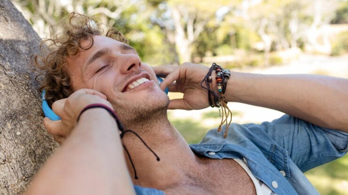    Мужчина в наушниках и с браслетами на руке:Freepik