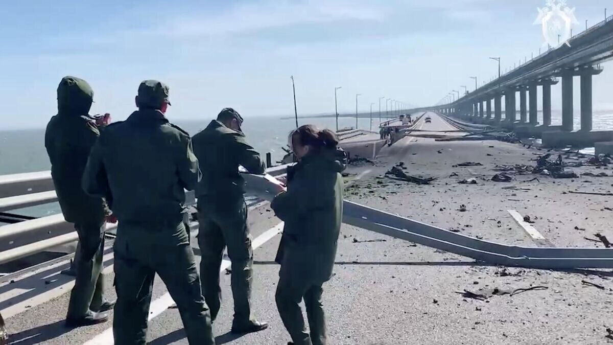    Сотрудники Следственного комитета на месте подрыва грузовика на Крымском мосту. Кадр из видео© СК РФ