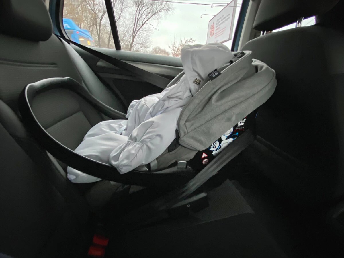 Малыш в кресле пристегнут трехточечным ремнём. 