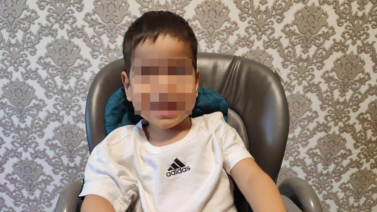    Мальчик сидит на стуле и улыбается:из личного архива