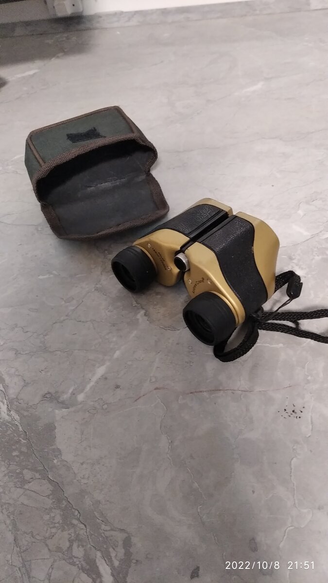 Бинокль с кошелёчком повёрнутый увеличительной стороной.