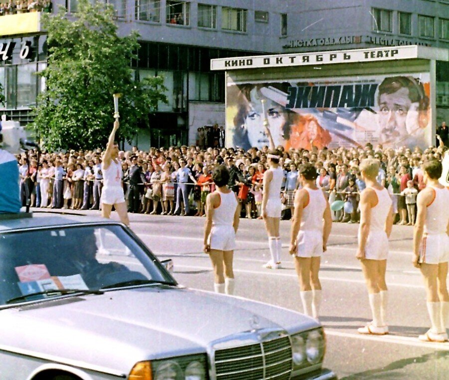 Олимпийский огонь в Москве на фоне афиши с фильмом "Экипаж" 1980 года