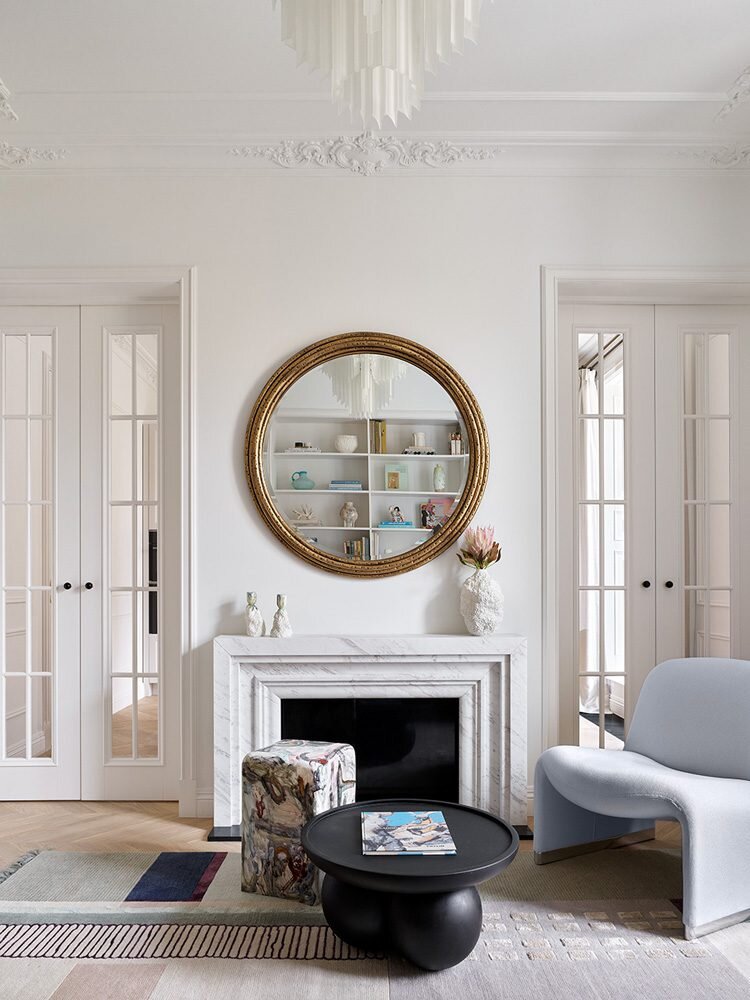 Московская квартира по дизайну бюро Elements Studio. Гостиная. Лепнина, Artpole. Паркет, Coswick. Кресло Alky, Giancarlo Piretti. Зеркало, Uttermost. Двери, буазери, камин и черный журнальный столик созданы по эскизам дизайнеров. Кофейный столик, Levadnaja Ceramics. Ковер, Tapis Rouge. Ваза и подсвечники на камине — автор Hey May, 4 ceramics showroom. Люстра Pulsar, Eichholtz.