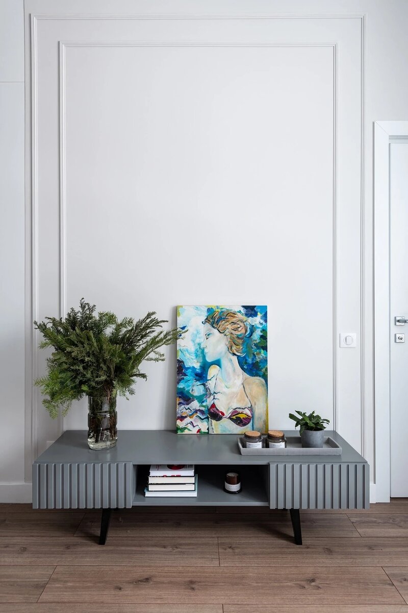 Участок стены напротив обозначили молдингами. Композиционно они воспринимаются как рама для картины на тумбе.